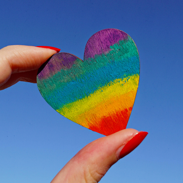 a hand holding a colorful knitted hat