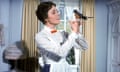 A woman (Julie Andrews) smiles as she looks at a bird in her hand