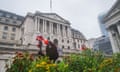 A view of the Bank of England in London with a bed of flowers in the foreground