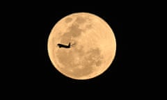 An aircraft flies past the supermoon as it rises in Brisbane, Australia.