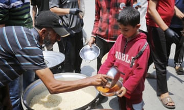 World Central Kitchen resumes work in Gaza<br>DEIR AL BALAH, GAZA - MAY 01: Members of World Central Kitchen serve meals to displaced Palestinians, in Deir Al-Balah province in the central part of the Gaza Strip on May 01, 2024. The international food charity World Central Kitchen (WCK) resumed its operations in the Gaza Strip on Tuesday after seven of its aid workers were killed in an Israeli strike earlier this month. Palestinians queued to receive food. (Photo by Ashraf Amra/Anadolu via Getty Images)