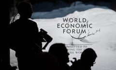 Participant are silhouetted in front of signage as they wait prior to a session at the World Economic Forum (WEF) meeting in Davos on January 17, 2024.