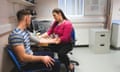 A young man getting his blood pressure taking by a female doctor