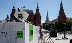 white van with green logo in front of two buildings