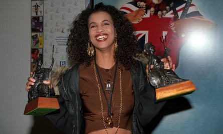 Neneh smiling and holding up the two Brit awards she won in 1990.