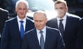 Vladimir Putin accompanied by Russian defence minister Andrei Belousov, left, and presidential aide Aleksei Dyumin, right.