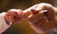 new baby holding the finger of its mother