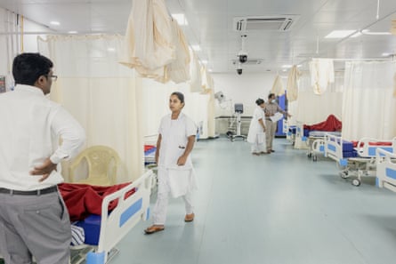 Indian medics stand by beds in a hospital ward