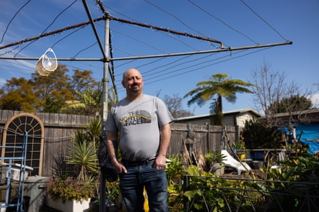 Guy Moore standing under a clothes line in a suburban backyard