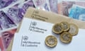 HM Revenue and Customs logos seen on letters and envelope, with coins on top and banknotes underneath