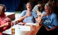 Three women gathered round a pub table with a quiz answer sheet, with one of them laughing