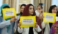 Women hold cards saying 'Recognise Gender Persecution'