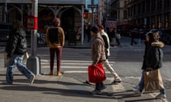 People walk with shopping bags at an intersection