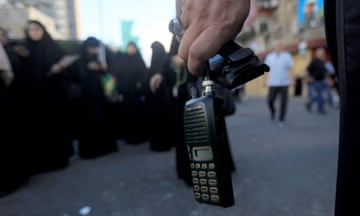 A person's hand holding a wireless communication device