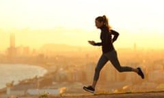 Woman running in city outskirts at sunset