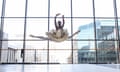 Michaela DePrince poses en pointe in front of interior full-length window