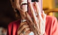 A woman laughing while using her smartphone