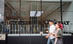 Two people walk past the Guardian and Observer offices in Kings Cross, central London.