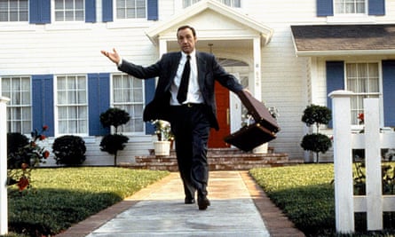 Kevin Spacey in a suit holding a briefcase that is open