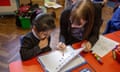 A teacher teaches a schoolgirl the alphabet