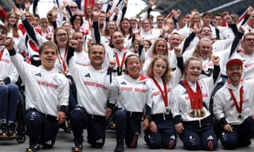 Paralympians in Great Britain kit wave at onlookers