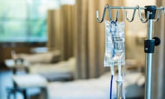 an IV bag hangs near hospital beds