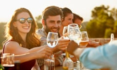 Friends toasting at dinner party<br>Group of friends toasting and laughing while having dinner outside