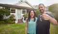 Happy mixed-race couple showing the keys of their new house.