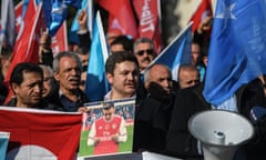 A supporter of China's Muslim Uighur minority holds a placard of Mesut Ozil