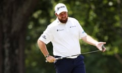 Shane Lowry of Ireland prepares to putt on the second green. He is wearing a white shirt with sponsors' logos, including Kingspan,  on the sleeves and chest