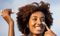 I protect my skin with sunscreen<br>A beautiful cheerful black woman is applying sunscreen on her face, she is enjoying a vacation and a little luxury in her life.