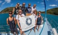 Group of people on a boat holding up a sign that reads "Citizens of the Great Barrier Reef".