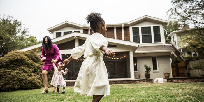 A mother looking to lock in a good HELOC rate plays with her two daughters in their yard