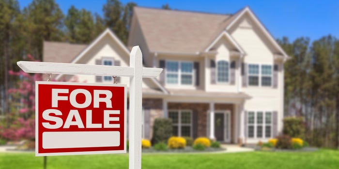 House with a 'for sale' sign in front of it