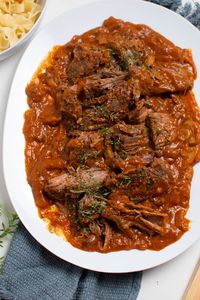 Make this hearty, flavorful, and delicious Crock Pot Italian Pot Roast! It's one of our favorite pot roast Crock Pot recipes. And it's the perfect main dish for Sunday dinner! This yummy dish features tender shredded beef covered in a zesty tomatoey gravy and it's perfect for a crowd. Everyone will love this amazing beef roast recipe