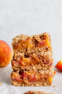 These Whole Wheat Peach Cobbler Bars are loaded with fresh peaches and a thick crust made with whole wheat flour! They’re not overly sweet, delicious and the perfect hand held dessert for Summer! #peachcobblerbars #peachpiebars #wholewheatdesserts #peachdesserts