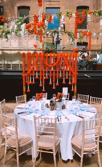 Beautiful Indian wedding at Devonshire Terrace London with wooden backdrop dressed with marigold garlands, and an overhead canopy of festoons, wisteria and marigolds