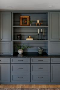 Blue-grey built in cabinets in kitchen, dark counter tops, horizontal ship lap