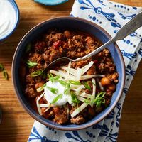 Chili cooks in just 15 minutes when it's made in a multicooker. The beef gets infused with the flavors of chili powder and cumin. Shredded cheese, scallion and sour cream round out the meal, but feel free to garnish with whatever toppings you choose.