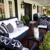 lovely front porch - love the black furniture and light fixtures. Love the floor color too.