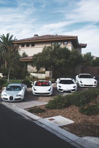 A Bugatti, a Ferrari, a Lamborghini and another Ferrari in front of a House