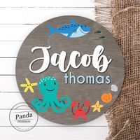 "We created this Ocean Animal themed nursery name sign with sweet, snuggly babies in mind! Made with birch wood, the Octopus add a sweetness to your Sea Creature nursery decor. All of our Circular Signs Feature: - Solid birch wood measuring .25\" thick. - Professionally printed design directly to the wood. - Comes equip with a sawtooth hook. - Back and sides are left natural. During checkout, please specify the personalization you would like added to the design. We will need to know: - Correct s