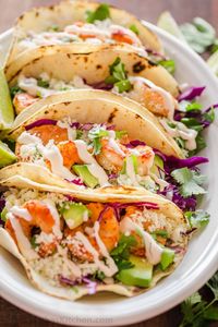 Shrimp Tacos are loaded with shrimp, cabbage, avocado, cotija, cilantro and served over gluten free corn tortillas. The shrimp taco sauce will win you over!