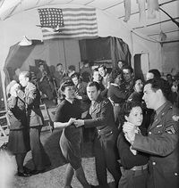 Credit: IWM via Getty Images British Land Army girls and members of the Women's Royal Air Force dance with men of the US Eighth Army Air Force #1940s #1940sfashion #ww2 #vintagephotography