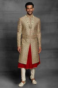 Look elegent in your wedding function with this golden hue raw silk dual layer sherwani with details of thread, sequins and beads work all over. having stand collar, full conceal button placket and vented hem. Comes with churidar.