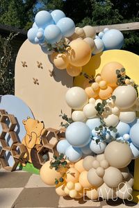 A classic winnie the pooh baby shower, light blue, neutral balloons, bee decor and neutral colors. 