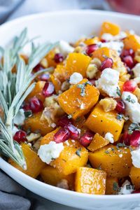 Roasted Butternut Squash with Goat Cheese is a simple recipe that packs in tons of flavor! Cubed squash is baked in the oven, then tossed with toasted nuts, pomegranate seeds, and fresh rosemary. Serve this easy and healthy side dish for holidays like Thanksgiving and Christmas, or whip it up for a weeknight meal.