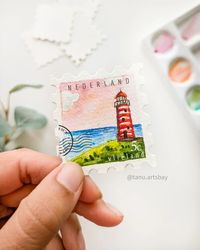 Day 21/100 Postal Stamp Series ⏩Swipe to see my cute little brush for giving details in this tiny little painting 😍 I'm having so much fun with these mini stamp paintings.🥳 Added the stamp signs digitally, just for fun 🤓 One question for my Dutch friends - When I looked for Dutch stamps, I saw ‘NEDERLAND’ written on many of them. Why is that? I tried looking it up, but I couldn’t find a good answer. I would Love to know about this 😊 Is it looking good with a postal stamp or without it?