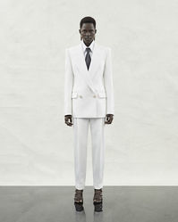 A Pre-SS24 double-breasted tailored jacket and trousers with a turn-up hem in white, a shirt in white cotton poplin and a tie in black. From the Alexander McQueen Pre-Spring/Summer 2024 womenswear collection by Sarah Burton. Photographed by Jet Swan.