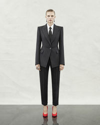 A Pre-SS24 tailored single-breasted one-button jacket and peg trousers in black and grey morning stripe wool, a shirt in white cotton poplin and a tie in black. From the Alexander McQueen Pre-Spring/Summer 2024 womenswear collection by Sarah Burton. Photographed by Jet Swan.